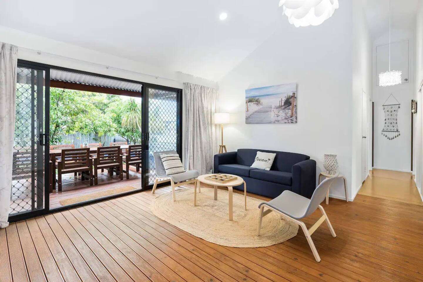 The Breezeway lounge with blue sofa and sliding doors open to the deck