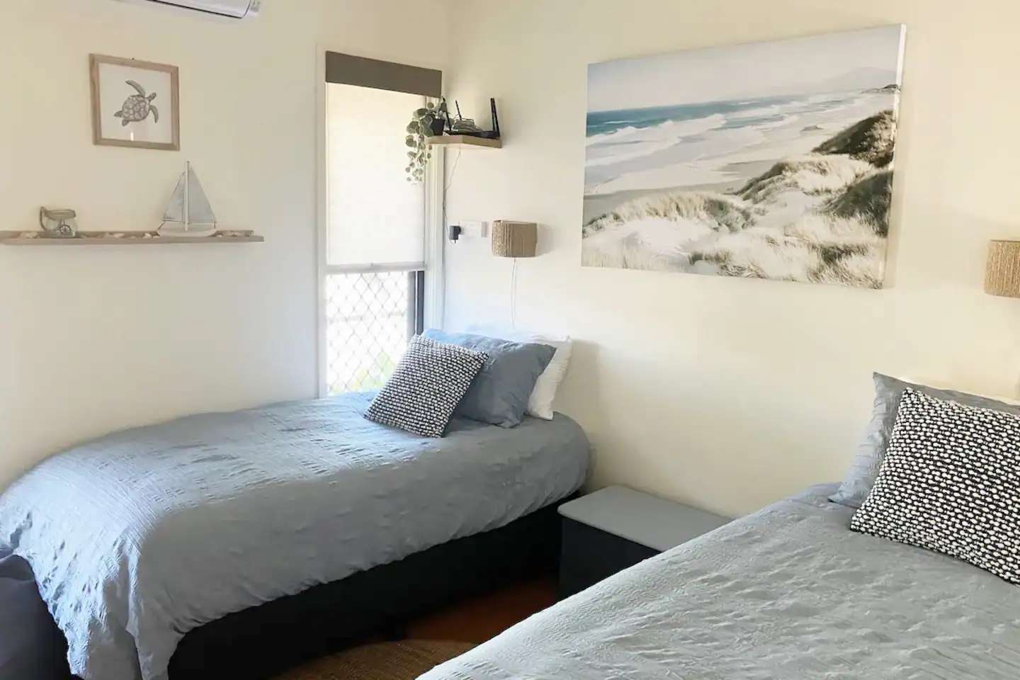 Two single beds with grey bedding in the third bedroom